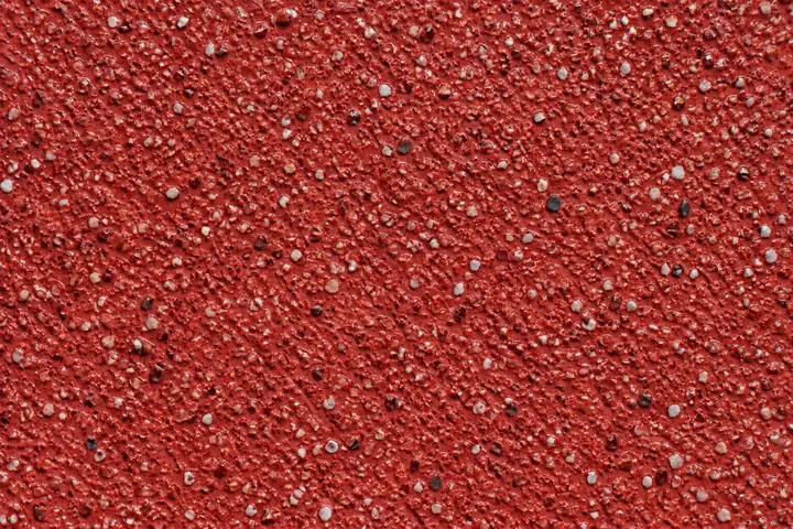 Close-up of red anti-skid surfacing on a pedestrian crossing approach