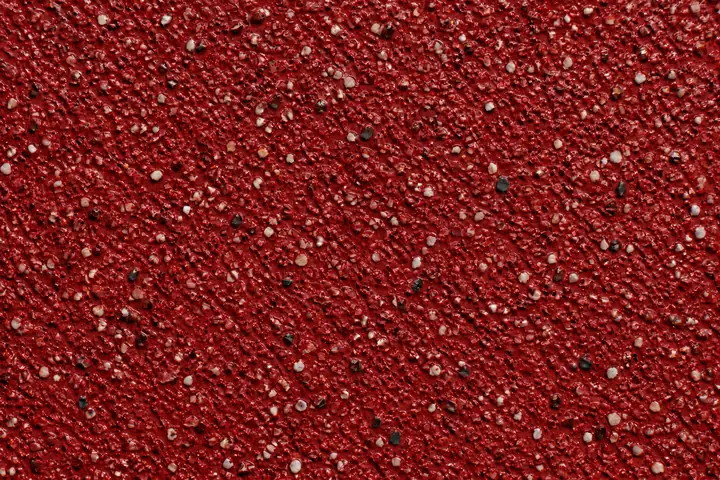 Close-up of red high friction surfacing used on bus lanes and red routes